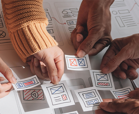 A group of people working together on a piece of paper.