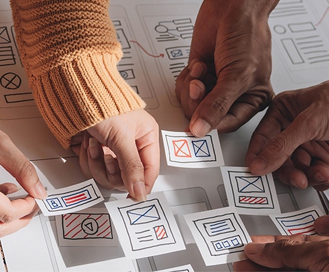 A group of people working together on a piece of paper.