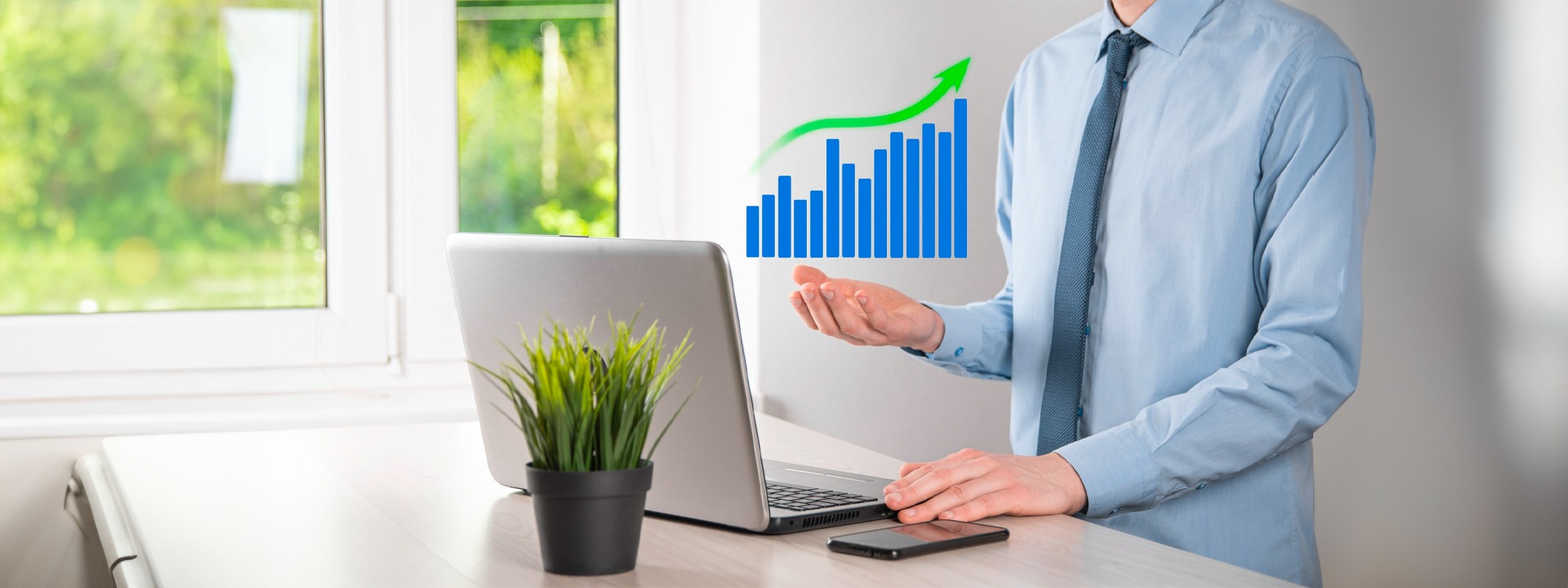 A man holding a laptop with a growth chart on it.