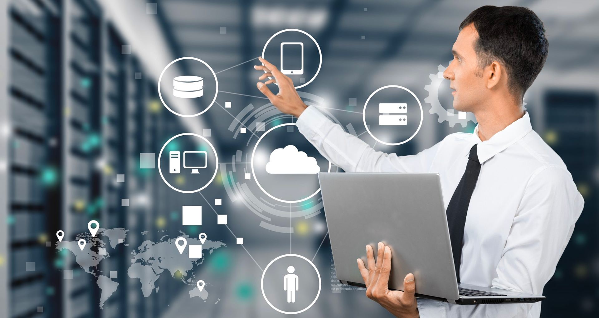 A man with a laptop in front of a server room.